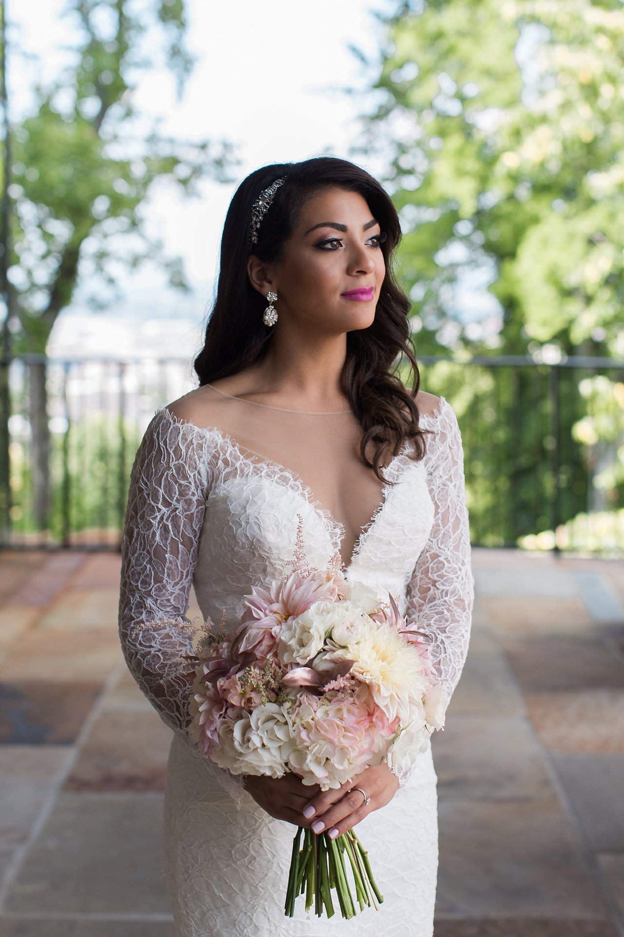 Modern wedding day portrait of bride wearing long sleeve lace wedding dress with plunging illusion neckline.